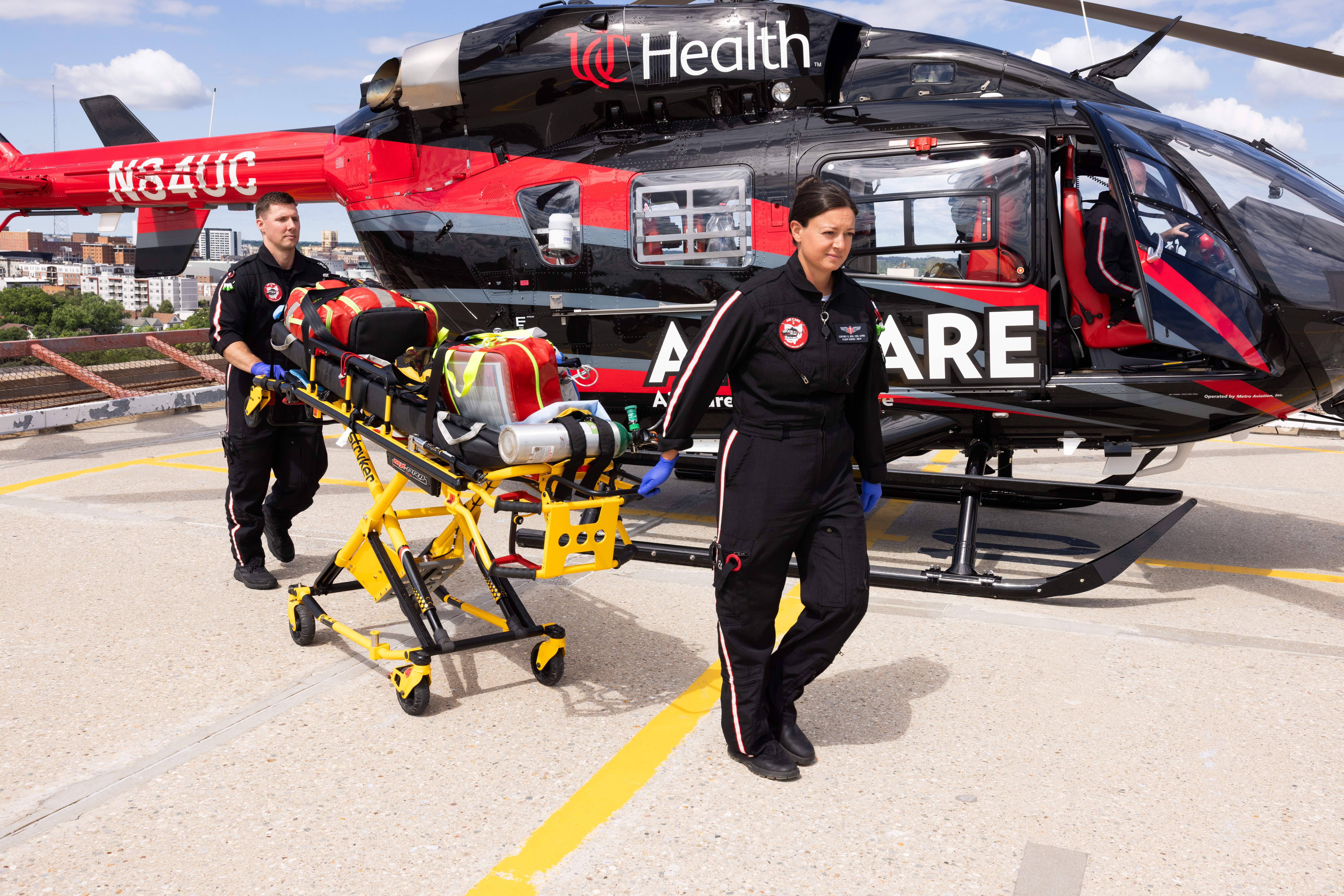 Air Care team transporting a patient on the UCMC helipad out of a helicopter. 