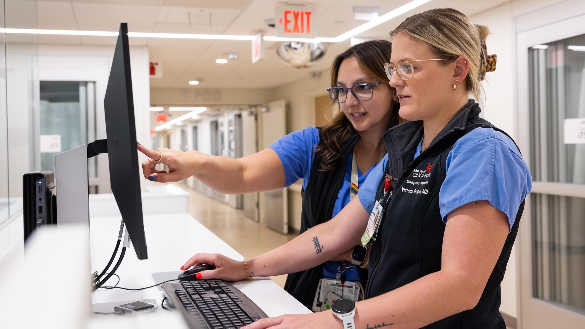 Two providers look at a computer monitor. 