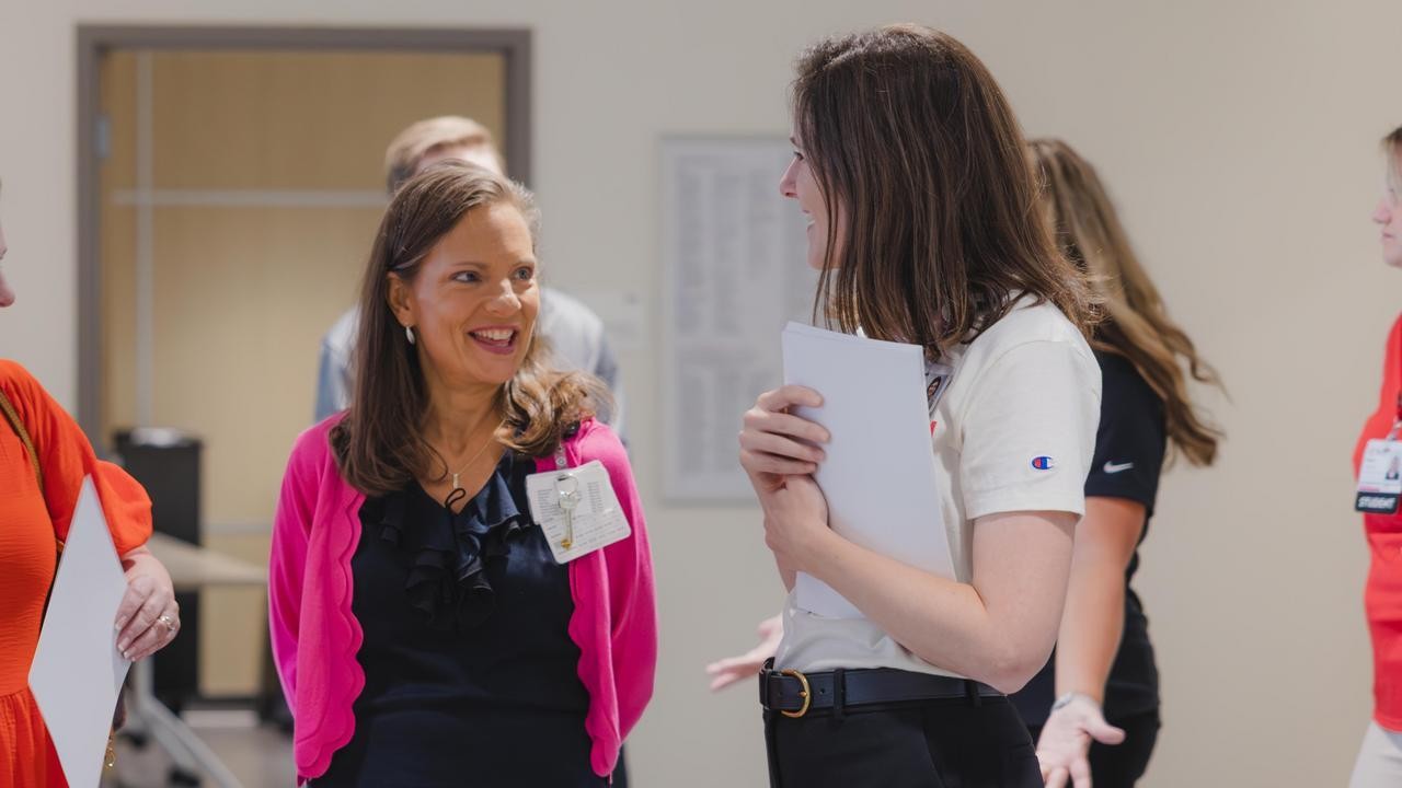 A group of people talk in a medical environment. 