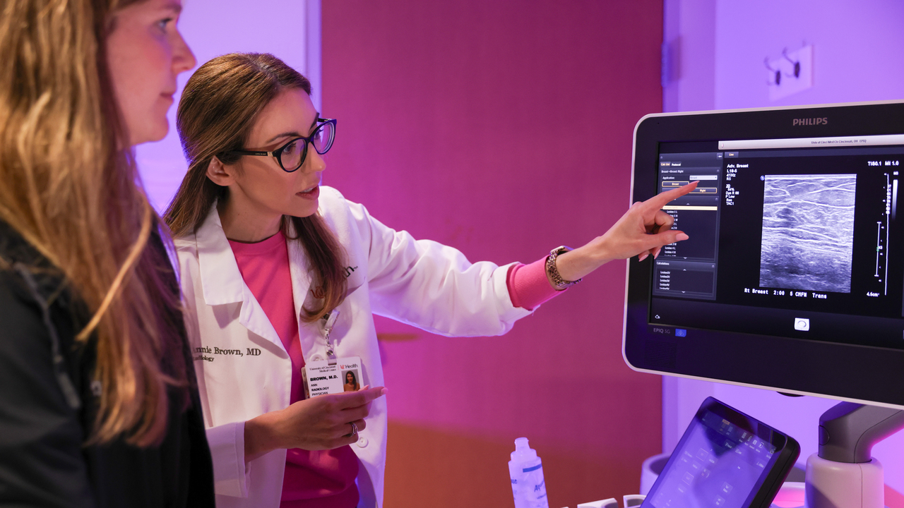 Medical providers look at a scan on a monitor. 