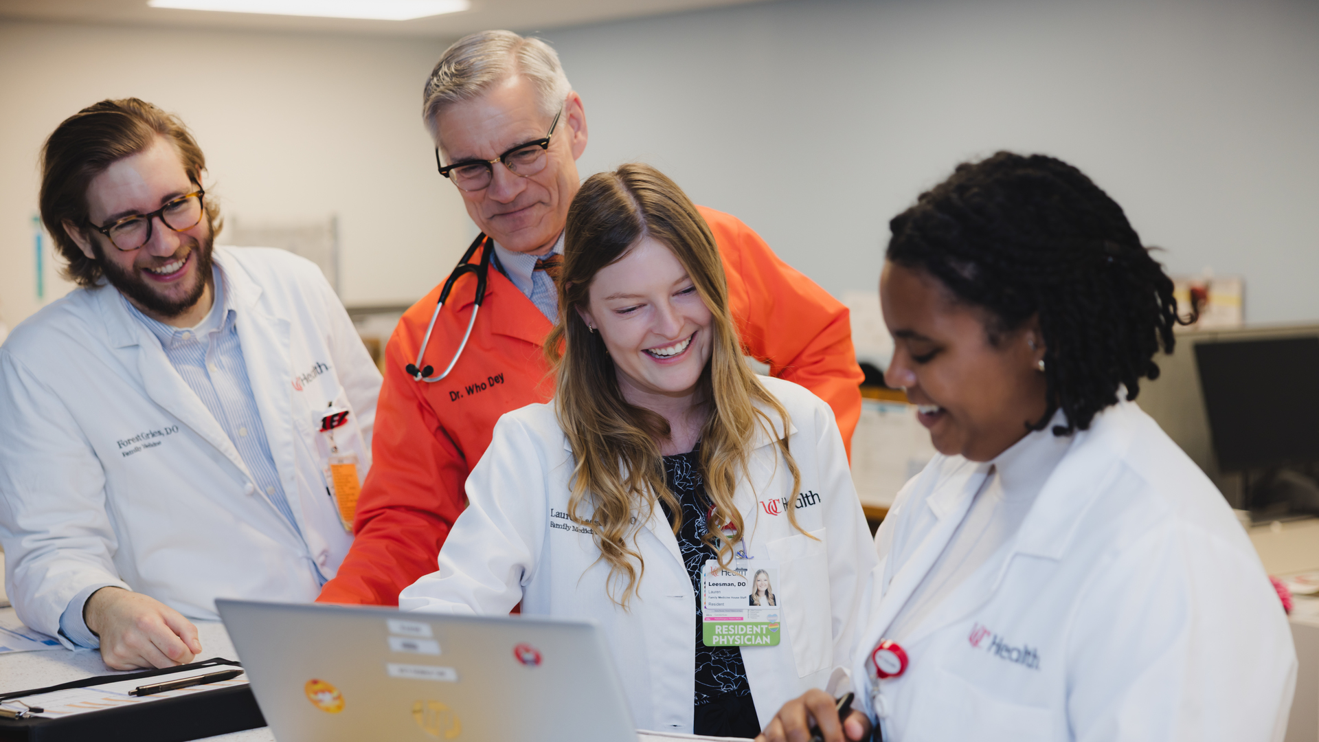 A group of providers look at a computer and talk. 