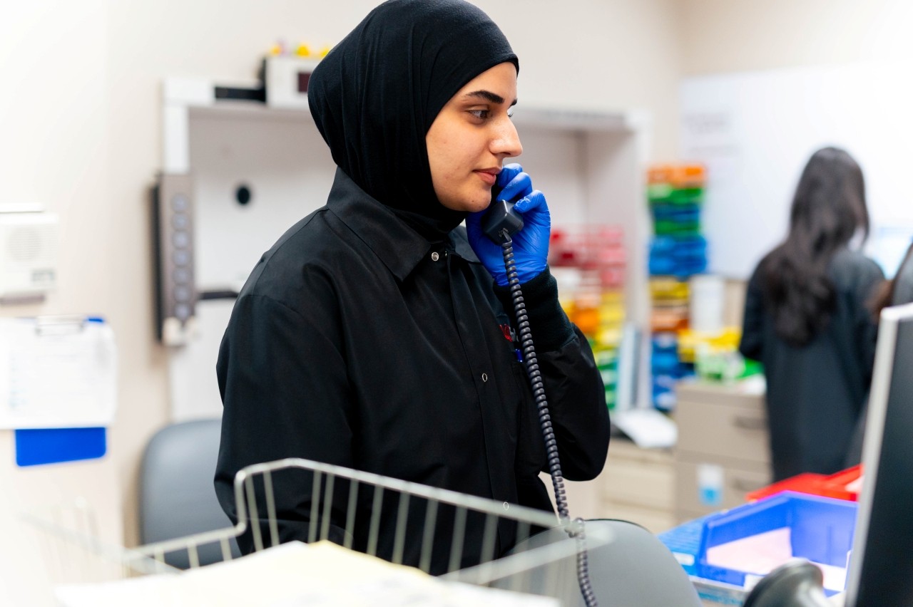 Technician holds phone while working in the core lab. 