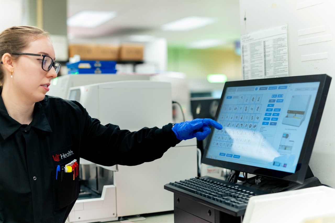 Technician in the core lab looks at a computer monitor. 