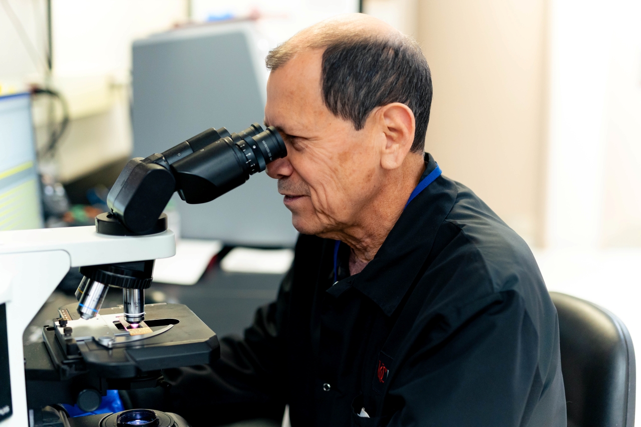 Lab specialist looks into a microscope.