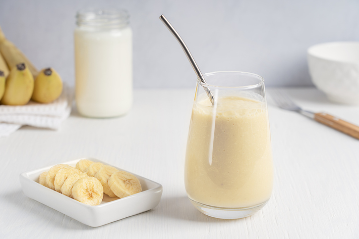 IBD-friendly banana smoothie displayed with additional bananas at the breakfast table.