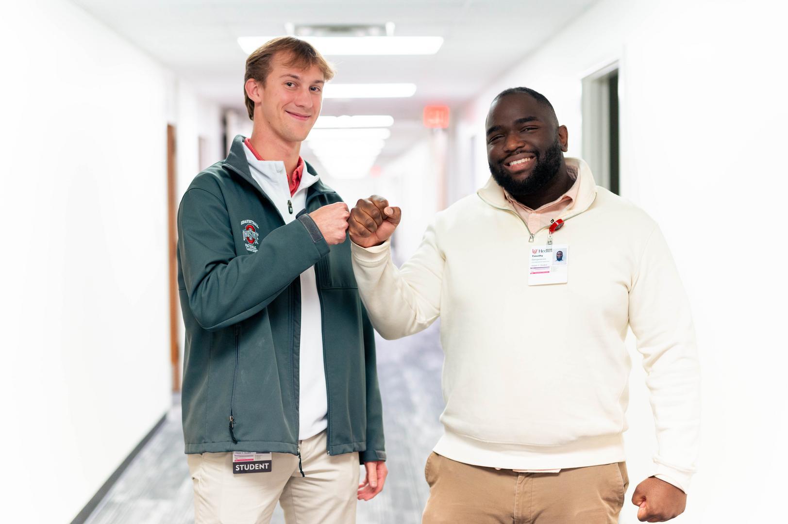 Two co-op students smile in hospital hallway