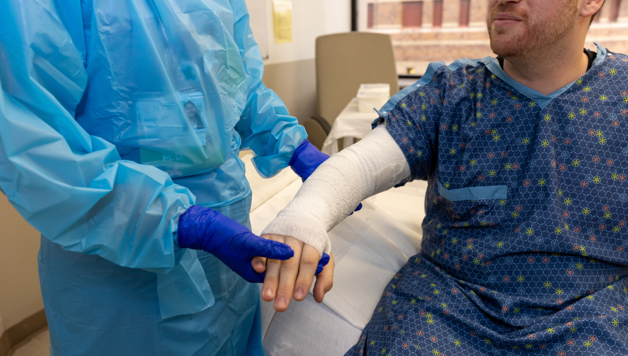 Care team taking care of Burn Patient's arm wound.