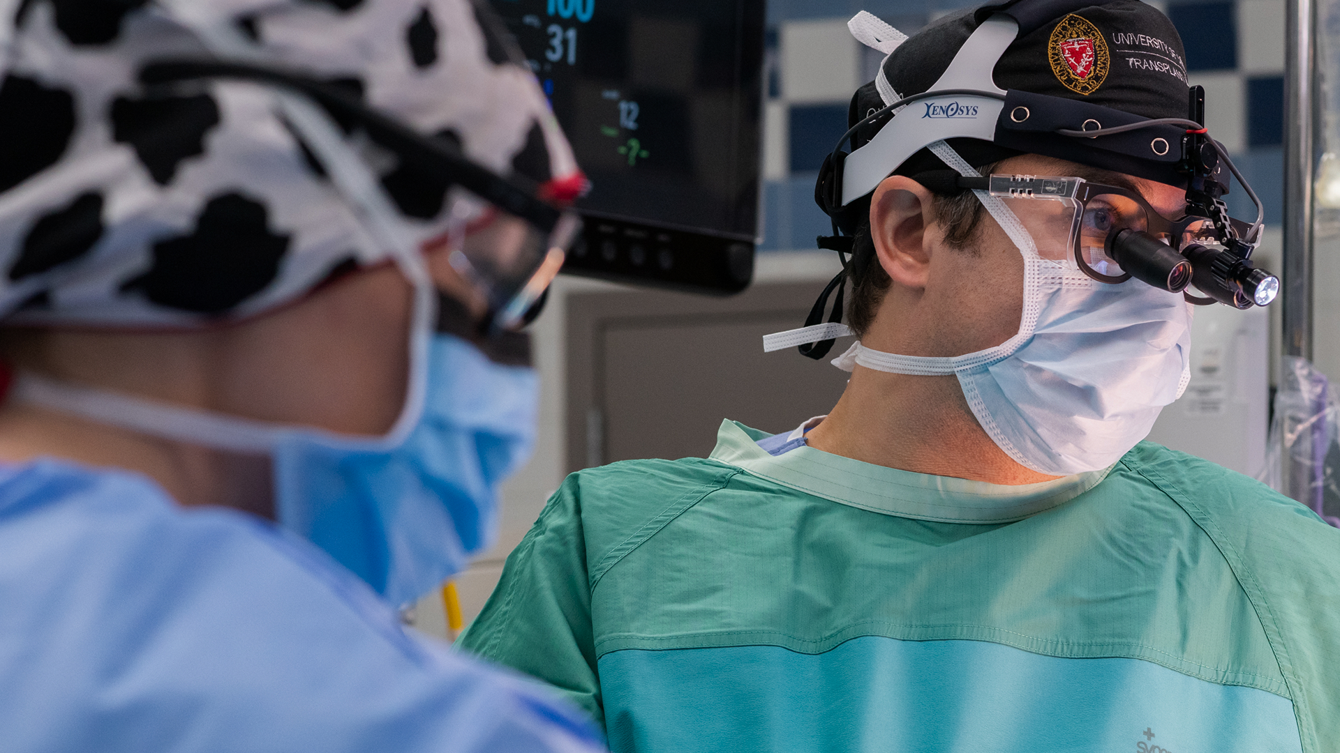 Surgeon and nurse look at liver transplant patient in operating room.