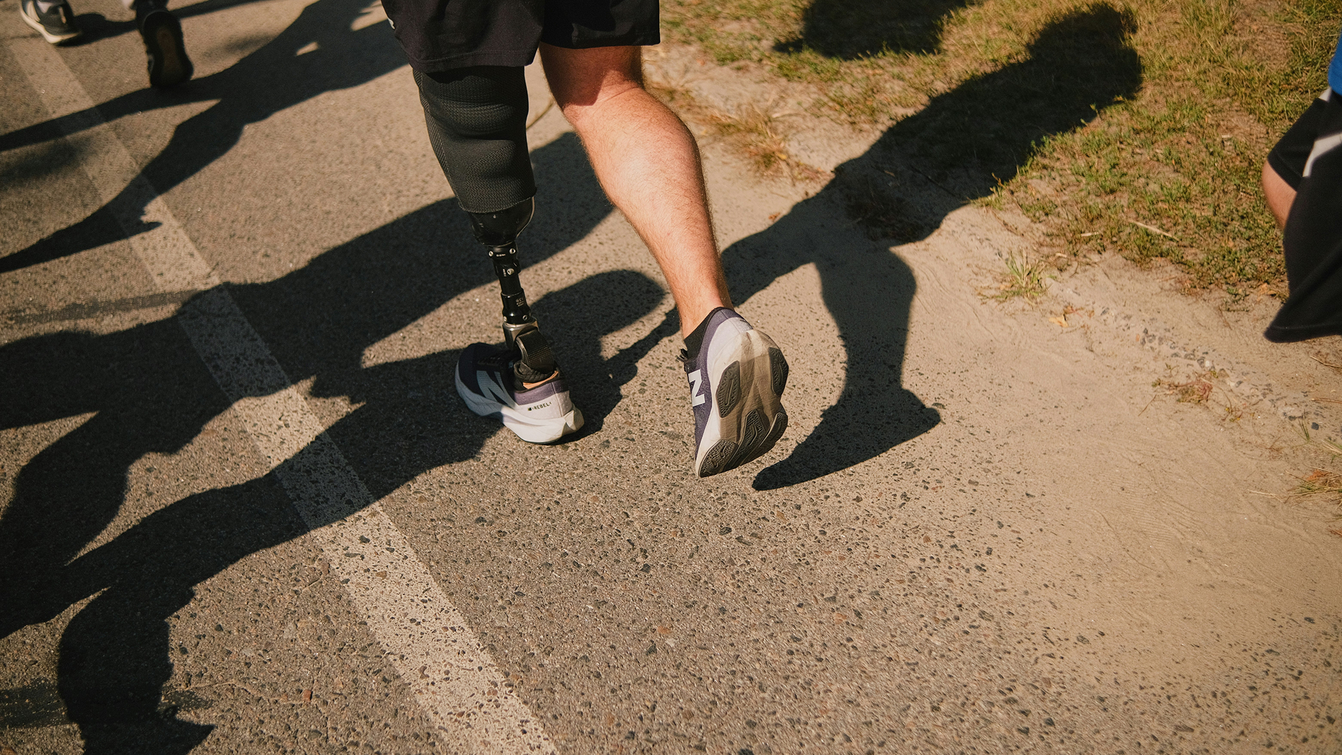Male orthopaedic patient with prosthetic leg running on trail.