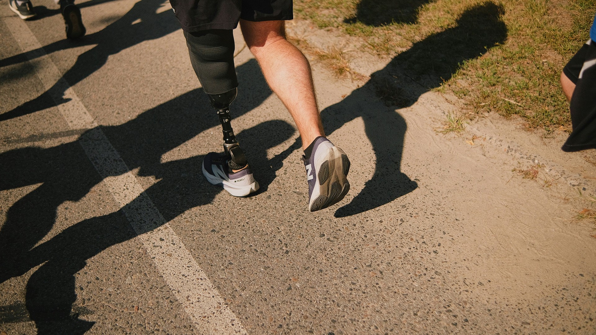 Male orthopaedic patient with prosthetic leg running on trail.