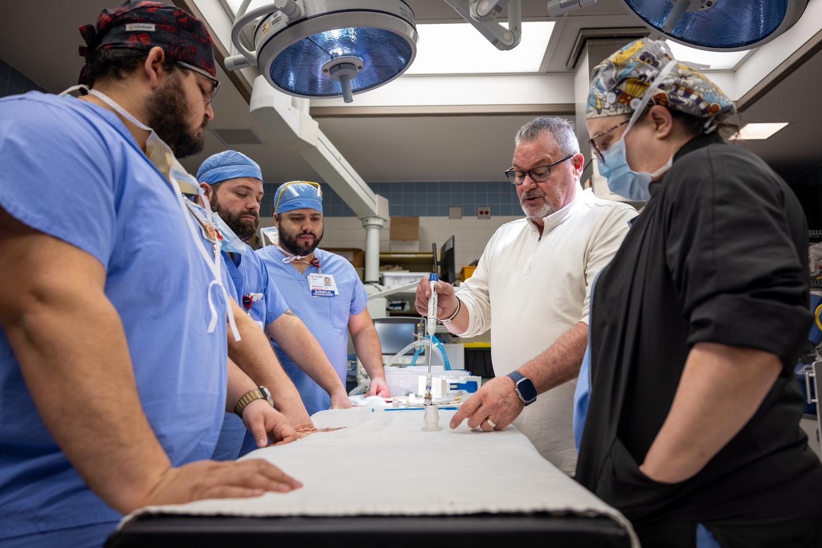 Physicians gather and discuss a medical procedure. 