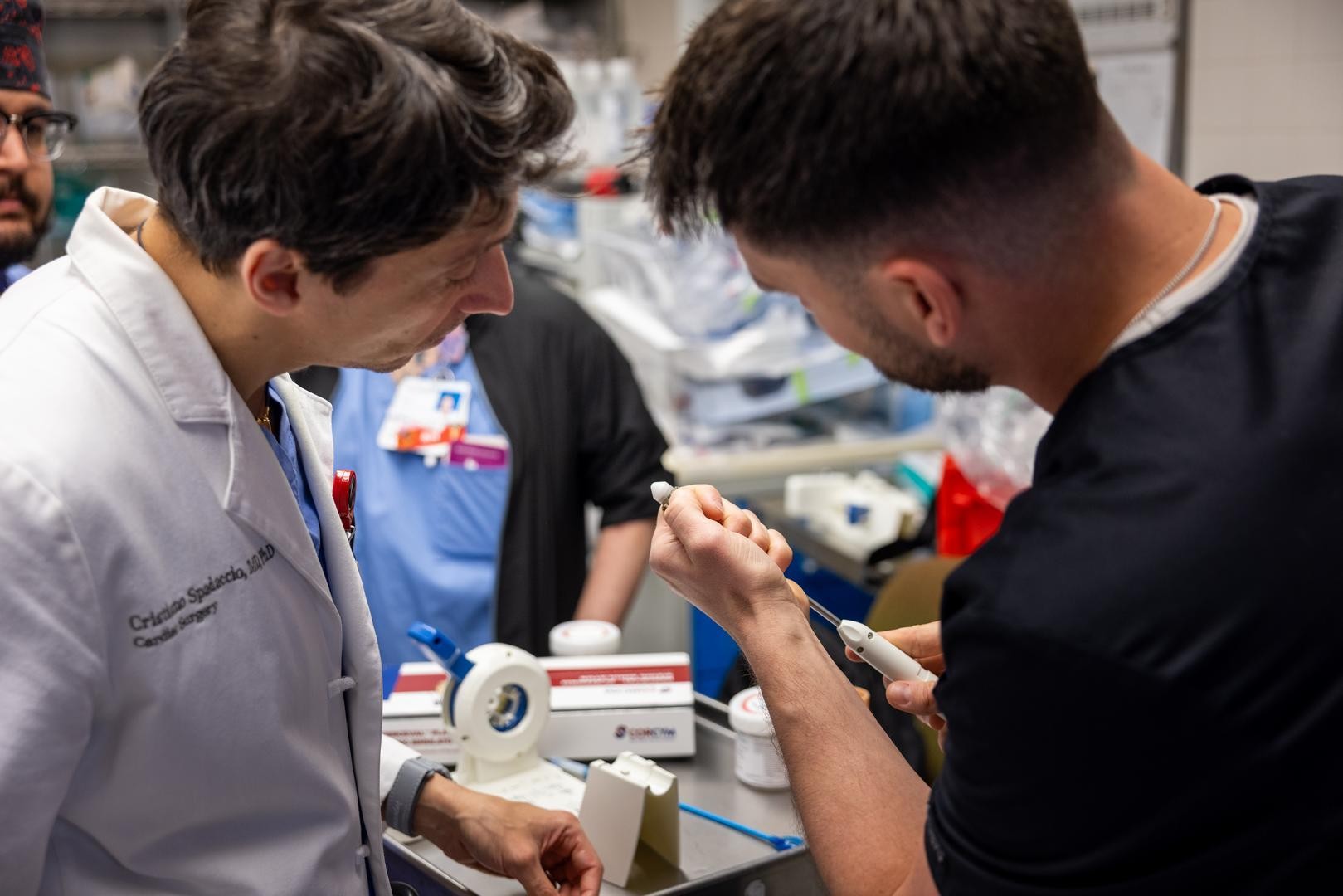 Two medical providers look at a device. 