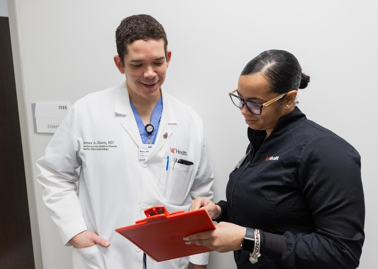 Two medocal providers look at a patient's chart. 