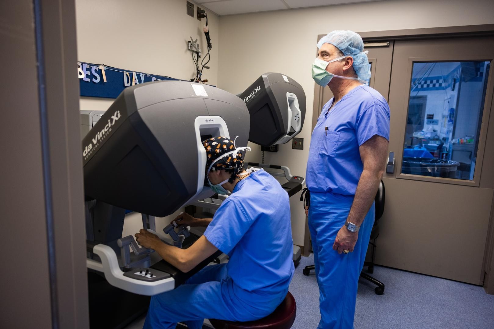 A physician works with a robotic device while another stands by.