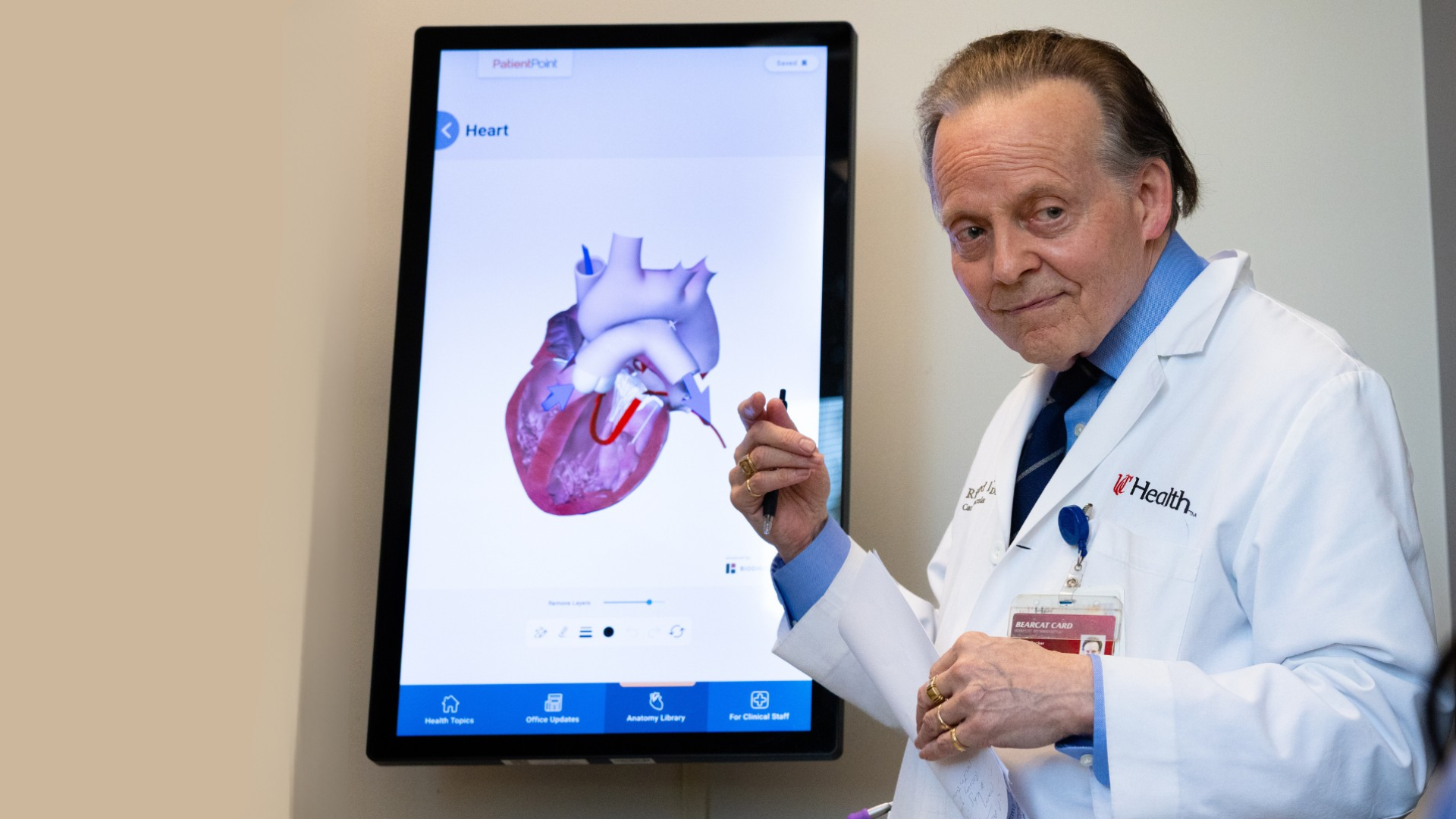 A physician talks with a patient and points at an illustration. 