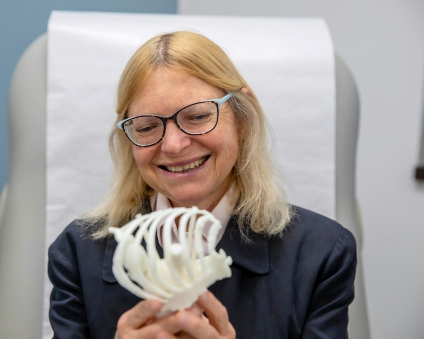 Patient looks at model of ribcage. 