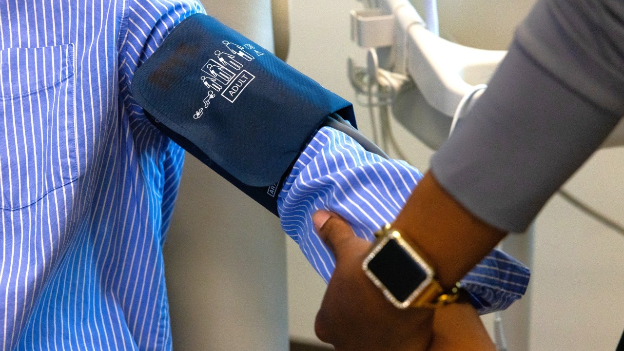A medical provider takes the blood pressure of a patient. 