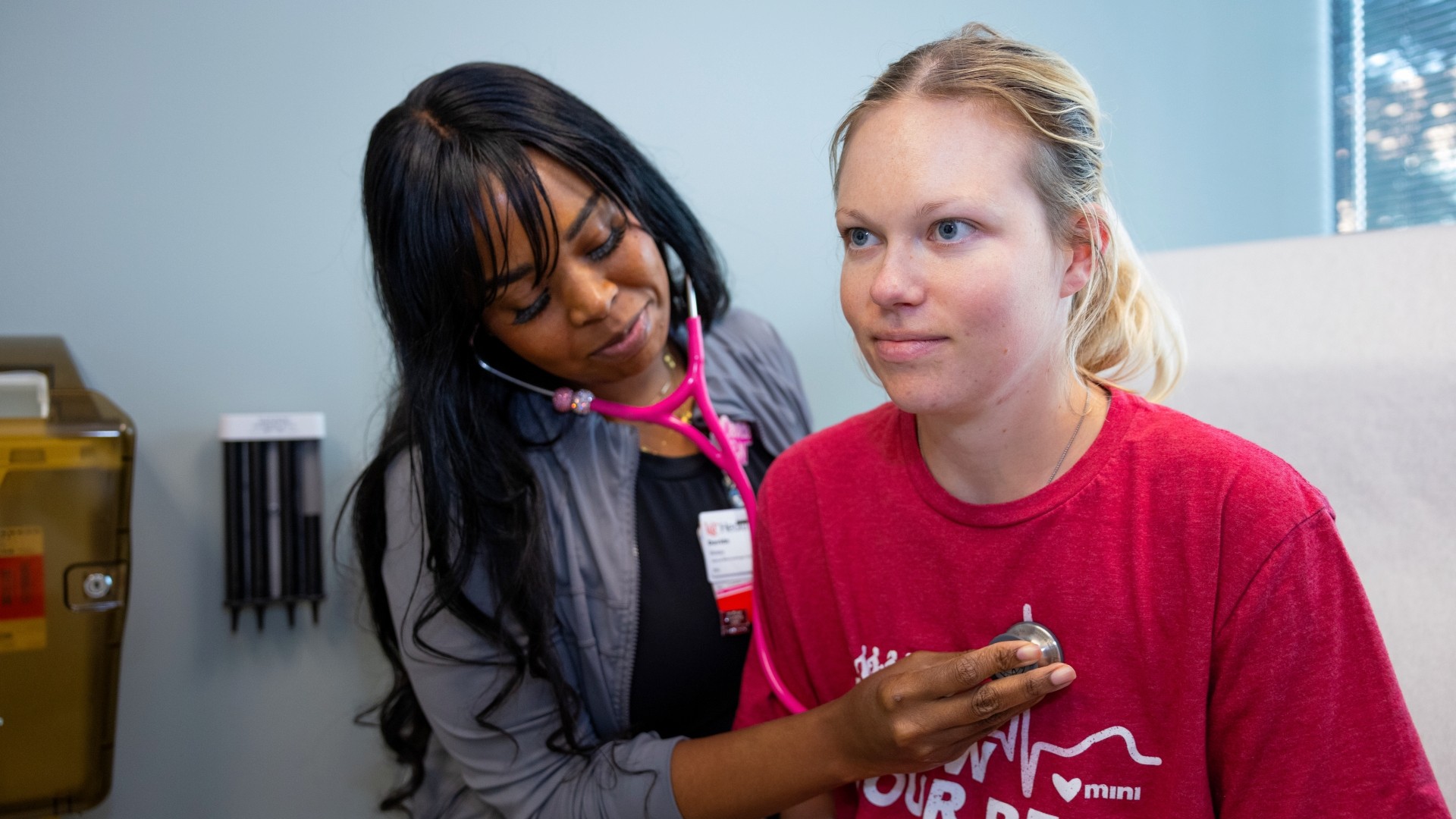 A medical provider examines a patient with a stethoscope.