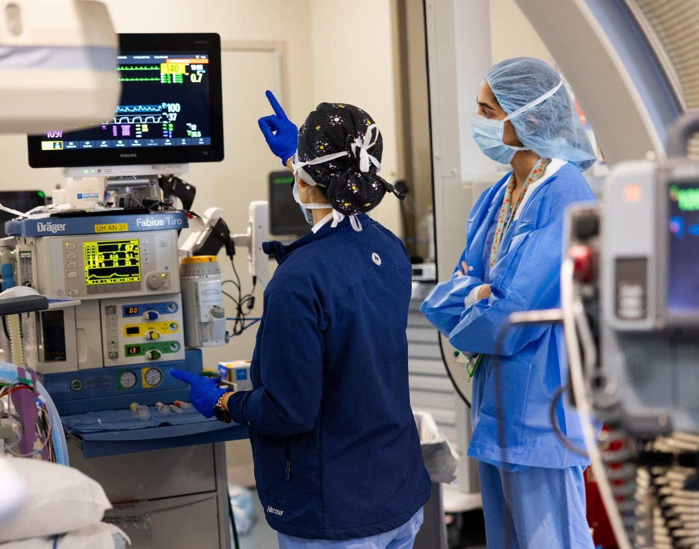 Two medical providers look at an image on a monitor. 