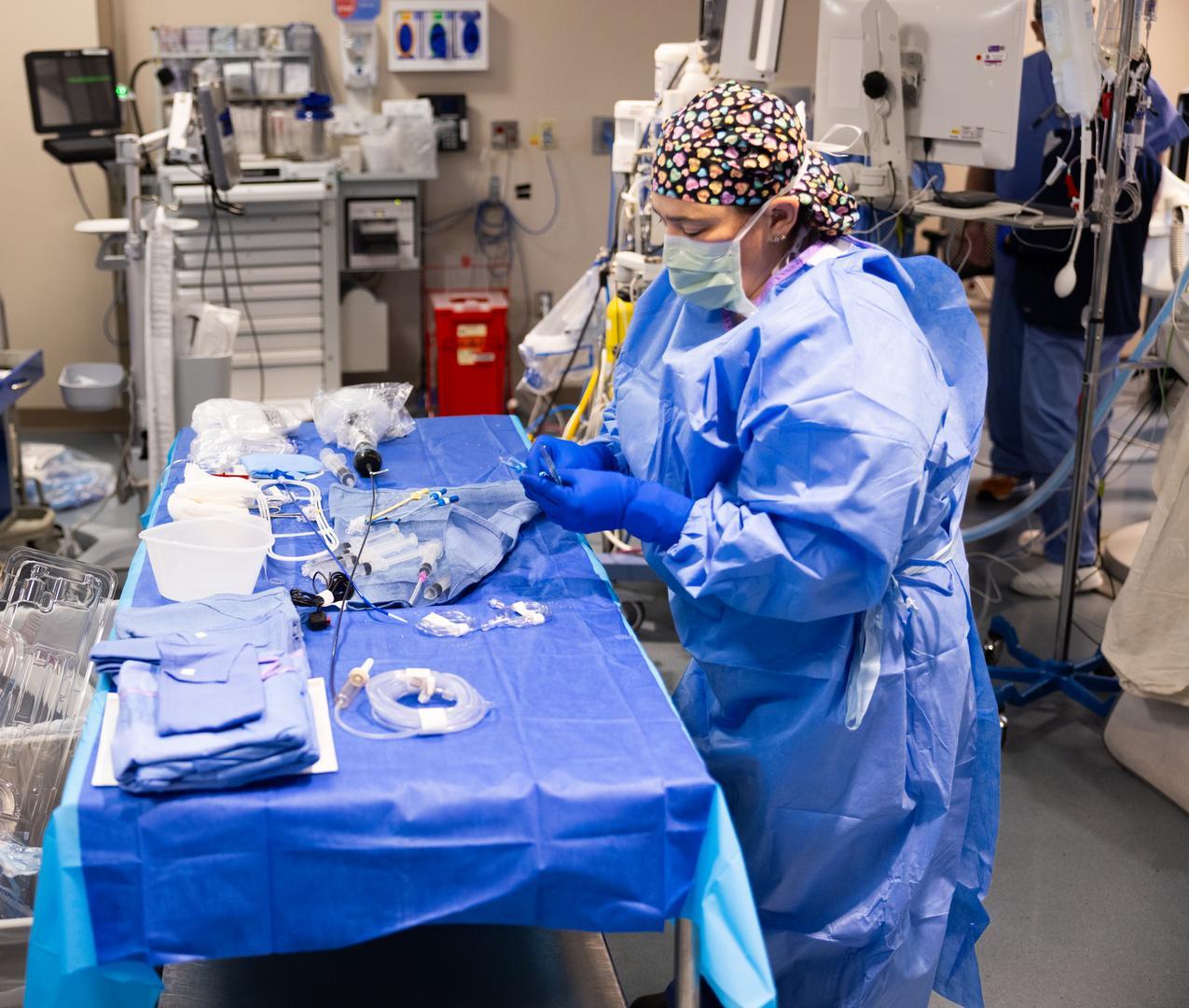 A physician works with surgical materials. 