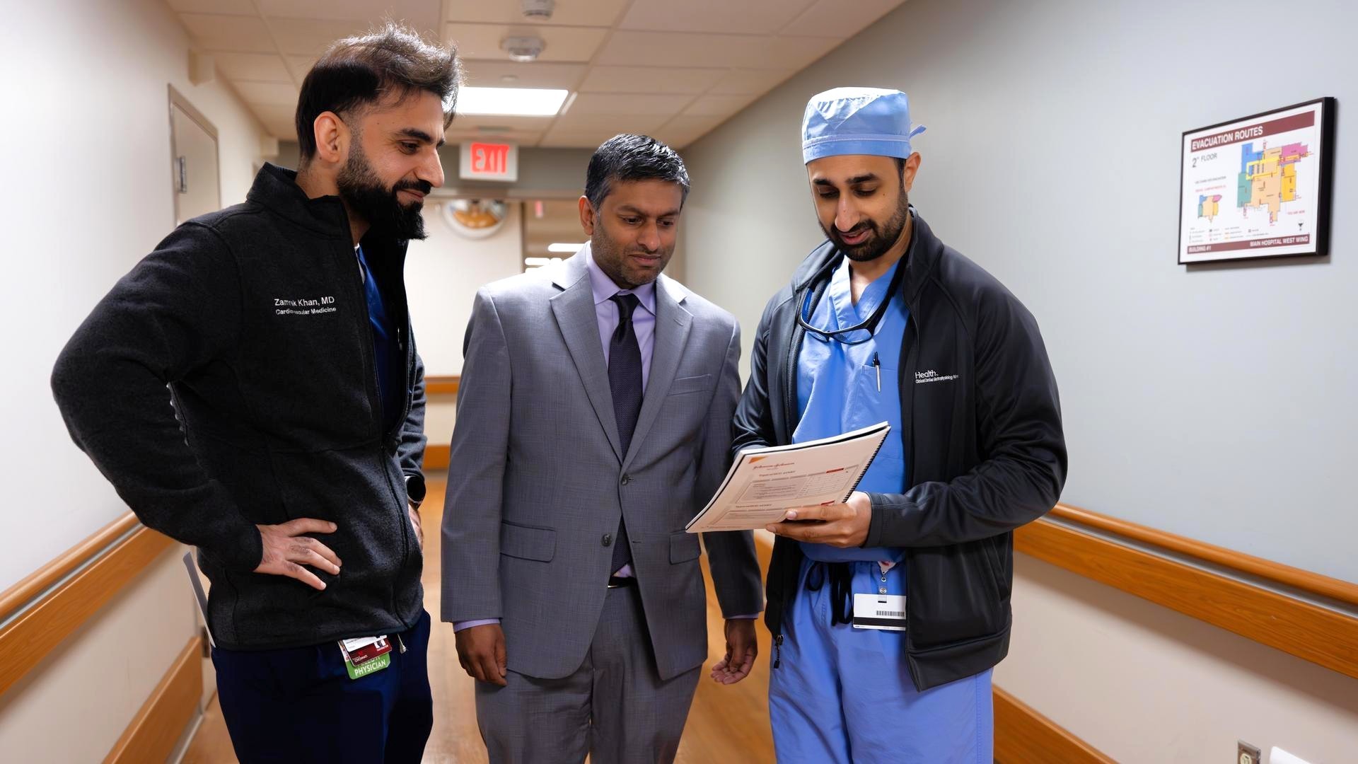 Medical providers talk in a hallway. 