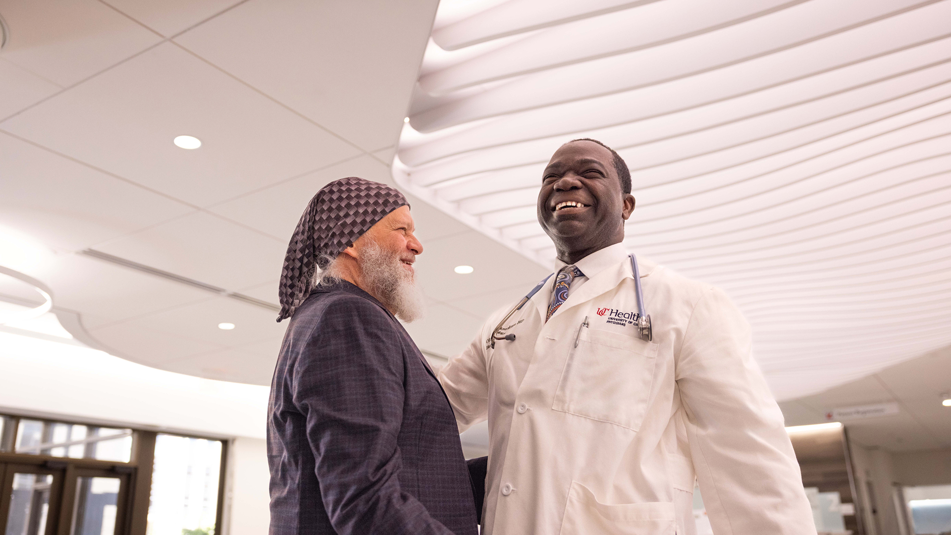 Cancer doctor and his patient smile in UC Cancer Center.