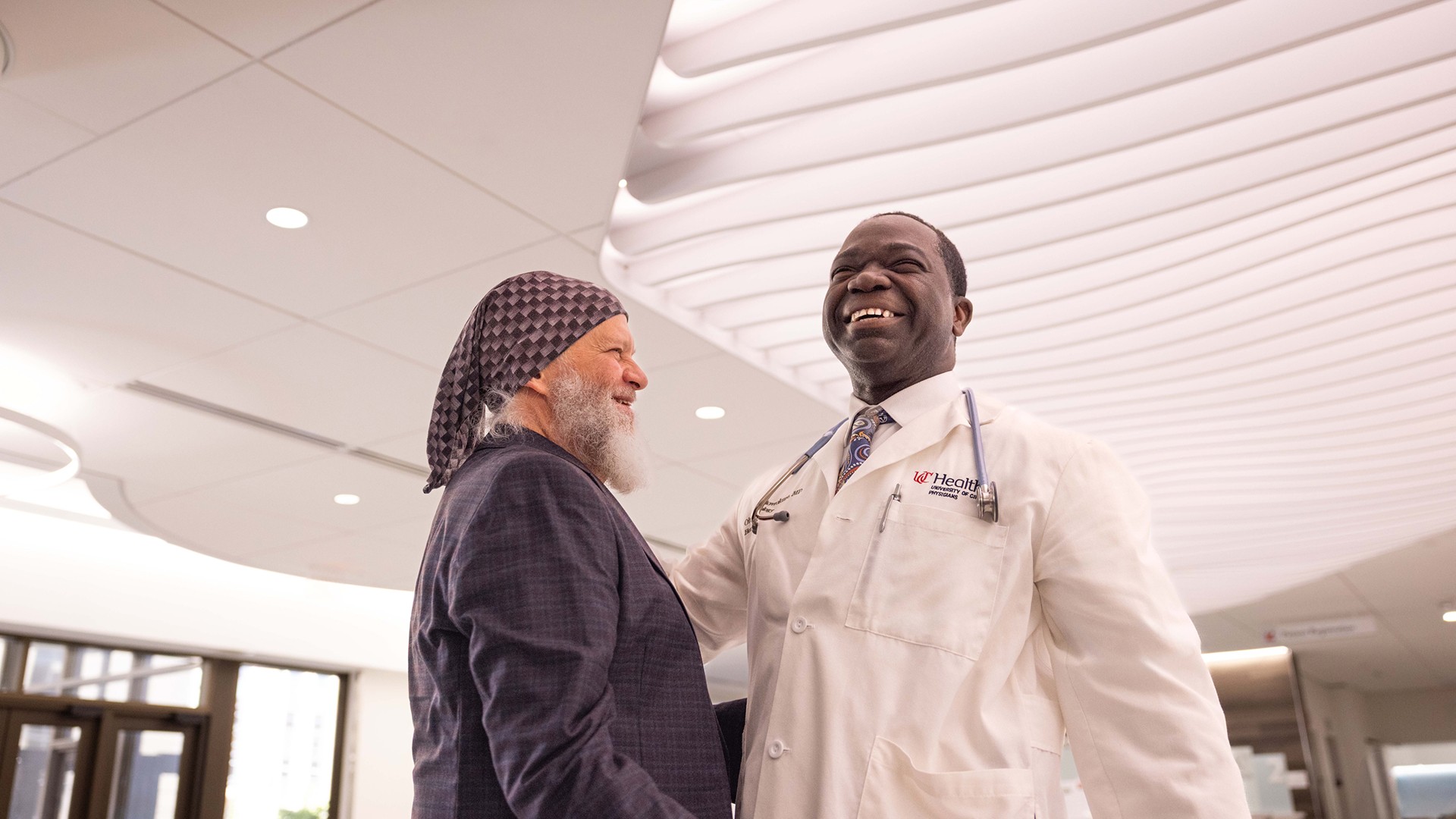 Cancer doctor and his patient smile in UC Cancer Center.