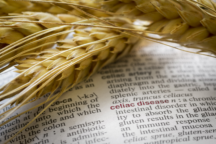 Celiac Disease text book with grains overlayed on the page. The word Celiac Disease is boled in red.