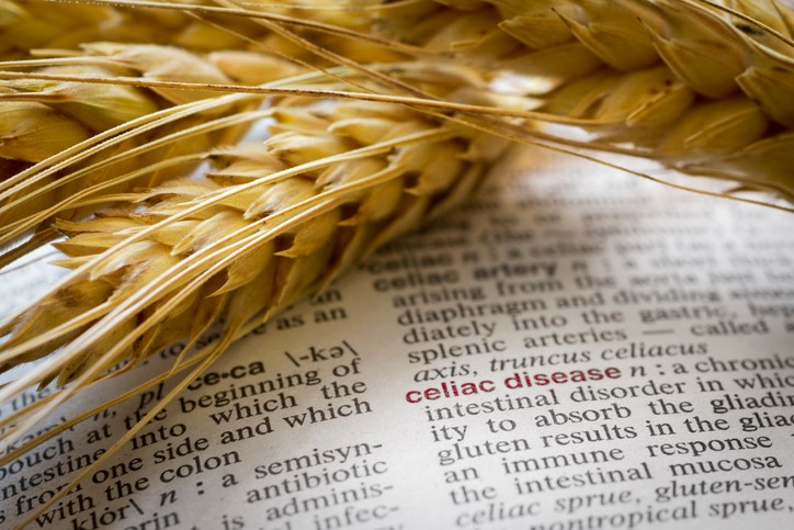 Celiac Disease text book with grains overlayed on the page. The word Celiac Disease is boled in red.