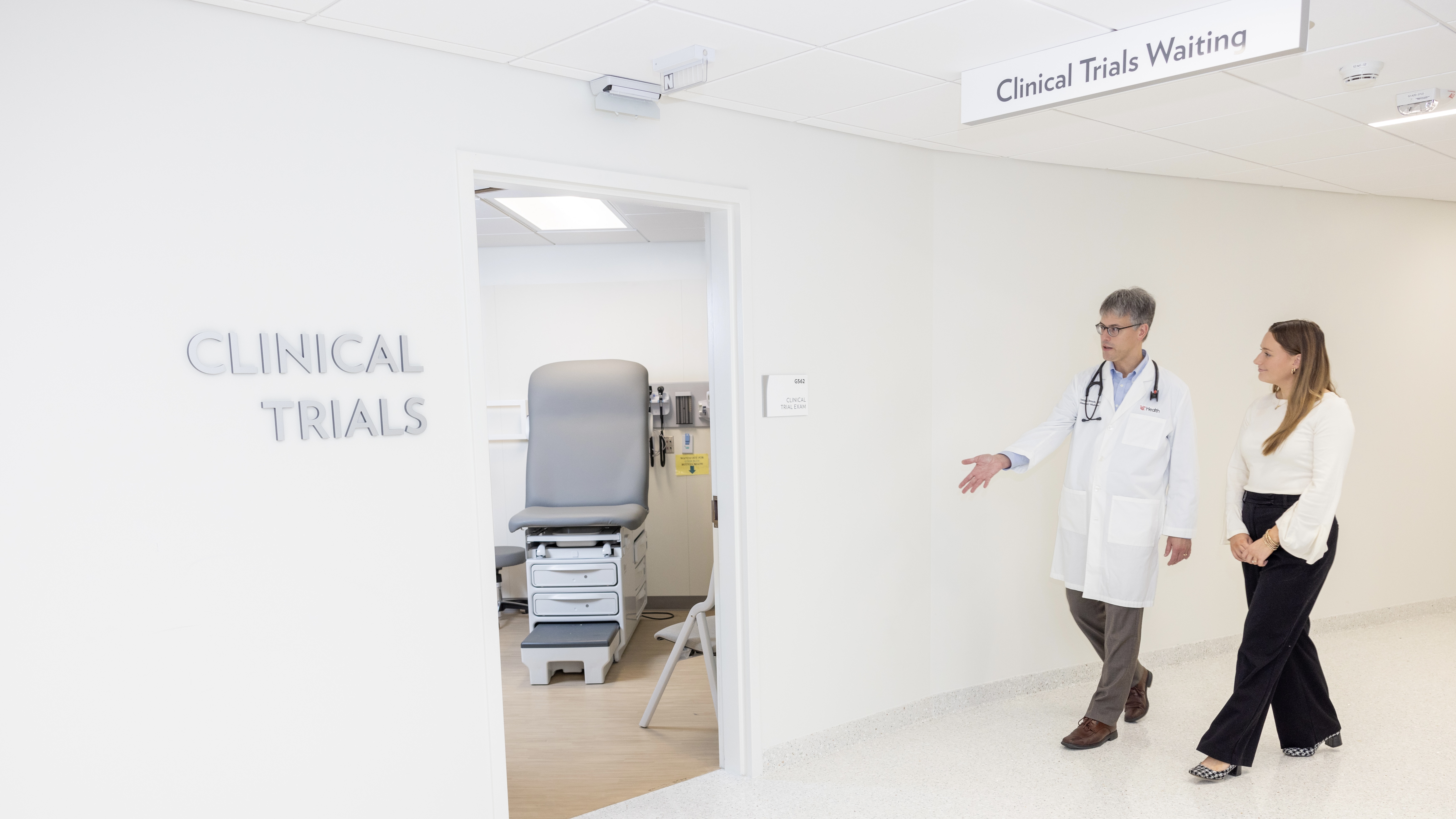 Doctor walking a patient to the Clinical Trials exam room.