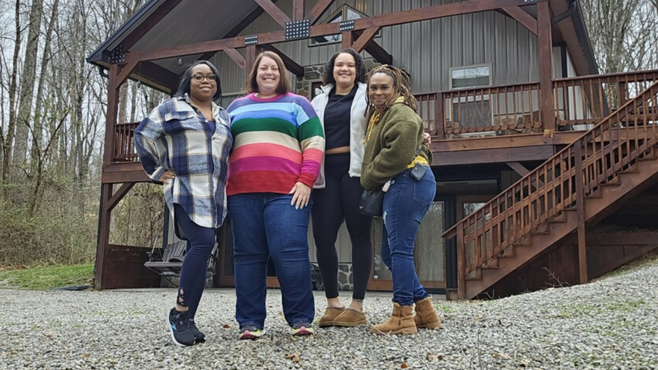 Kristen and group of three friends in front of a cabin