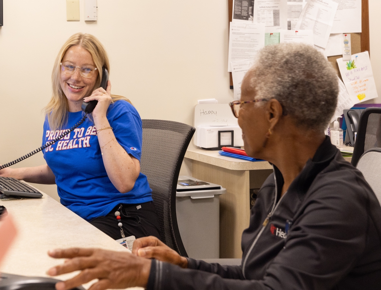 Two UC Health team members at reception desk 