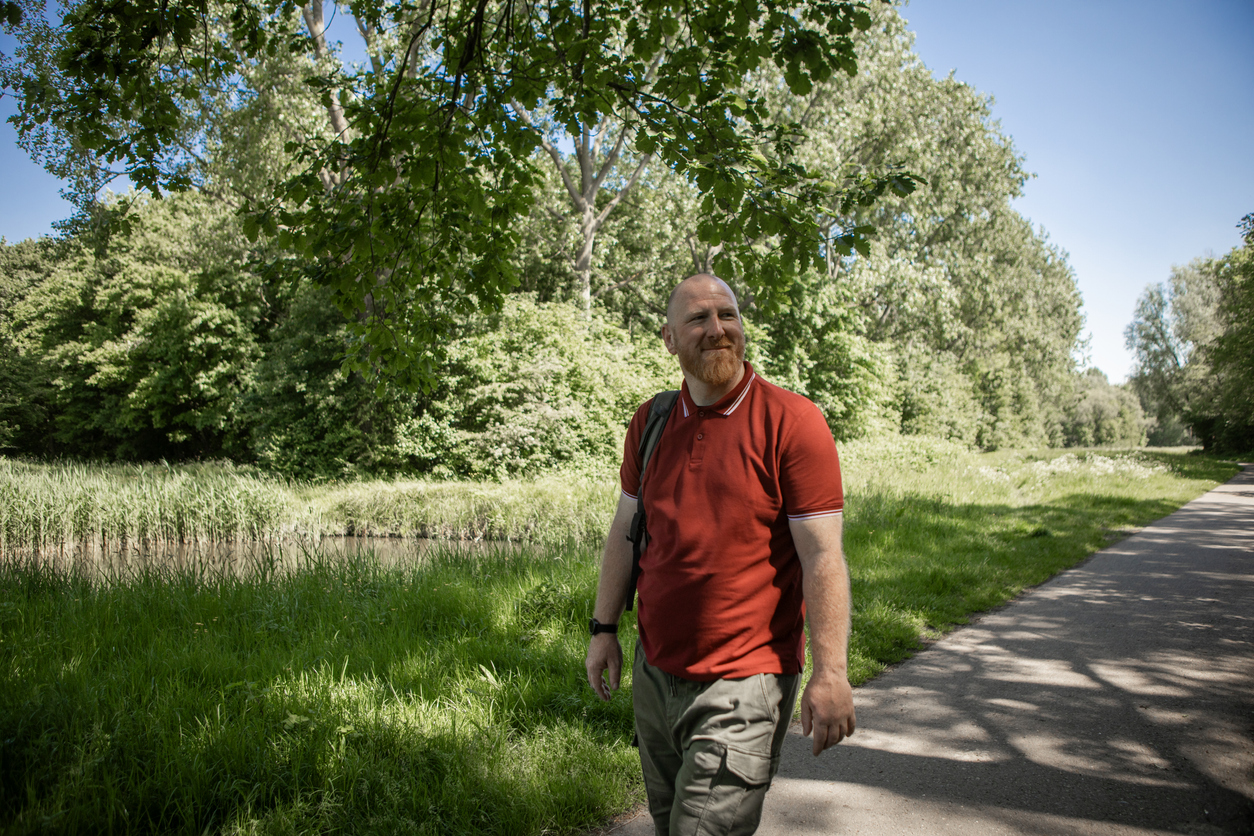 Man walks outside down a path enjoying the day