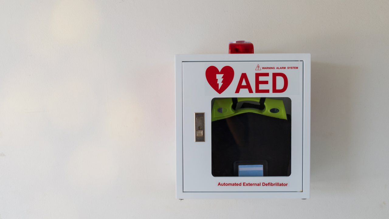 An AED mounted in a case to a wall