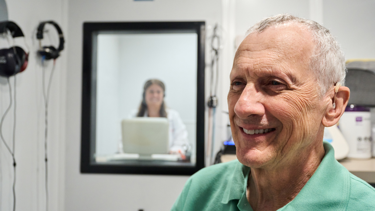 Patient smiles while recieving an audiology screening at UC Health