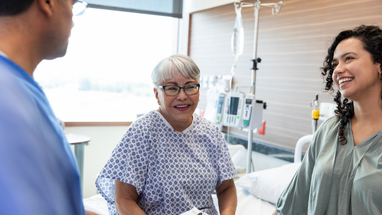 Woman and her daughter speak with her doctor in a hospital room