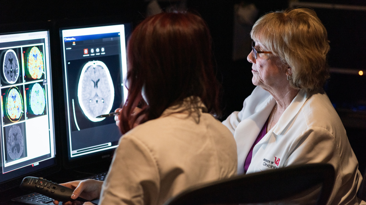 Two researchers at UC Health review imaging on a computer screen