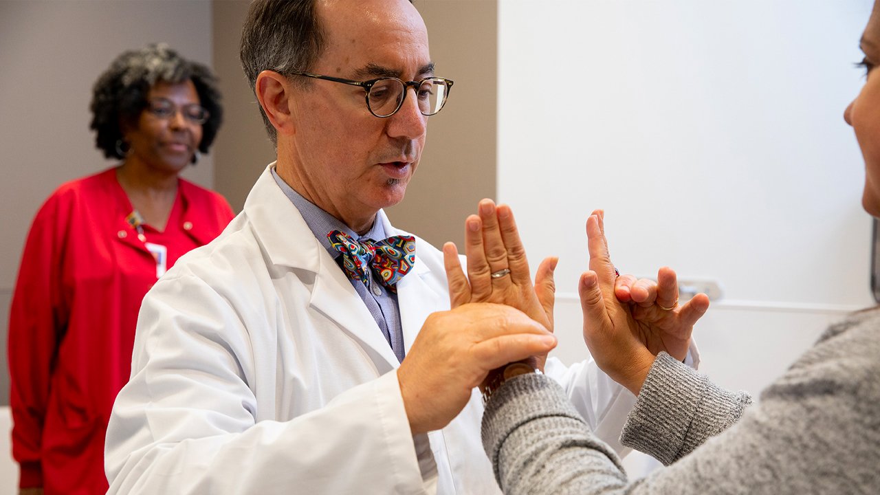 Physician attends to patient's hands. 
