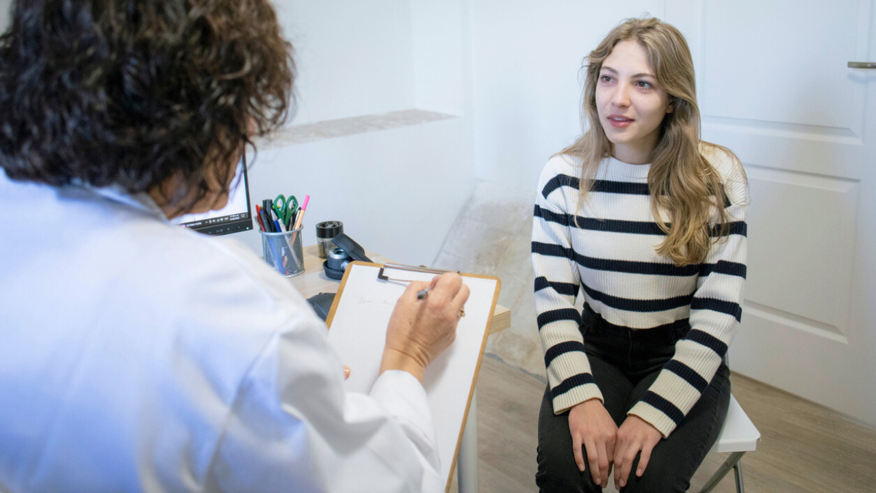 Woman in her 20s speaks with a doctor during an annual visit