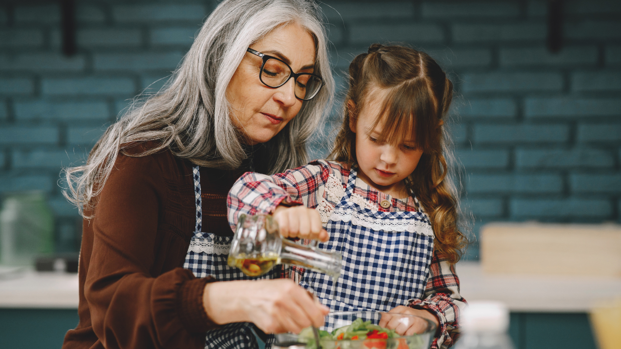 Woman prepares a salad with a young girl