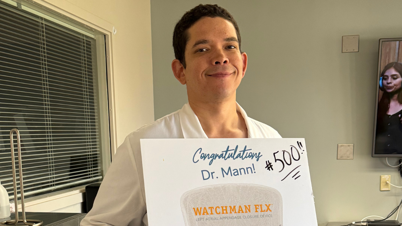 Dr. Mann holds a sign to commemorate 500th WATCHMAN procedure