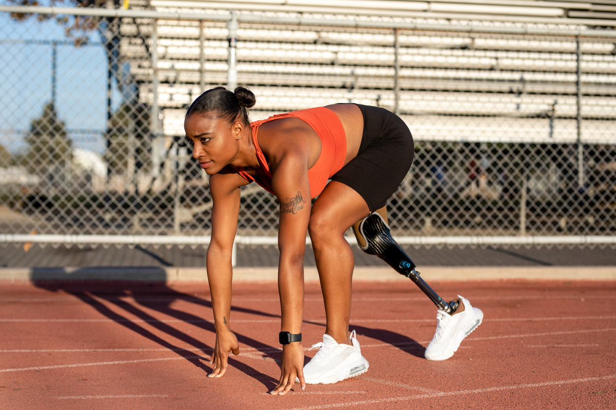 Runner with a prosthetic leg gets in position at the starting line before a race
