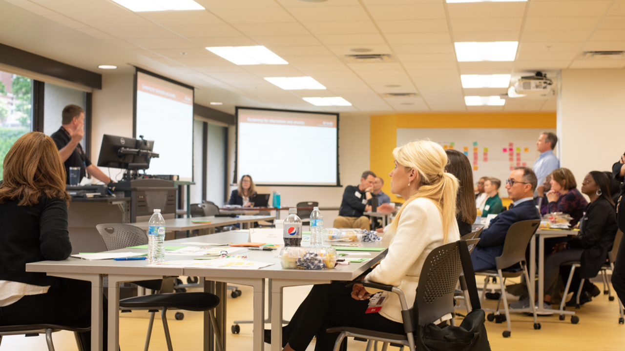 Dr. Ficker at UC Gardner Neuroscience Institute stands at front of a conference room leading conversation with Epilepsy team.