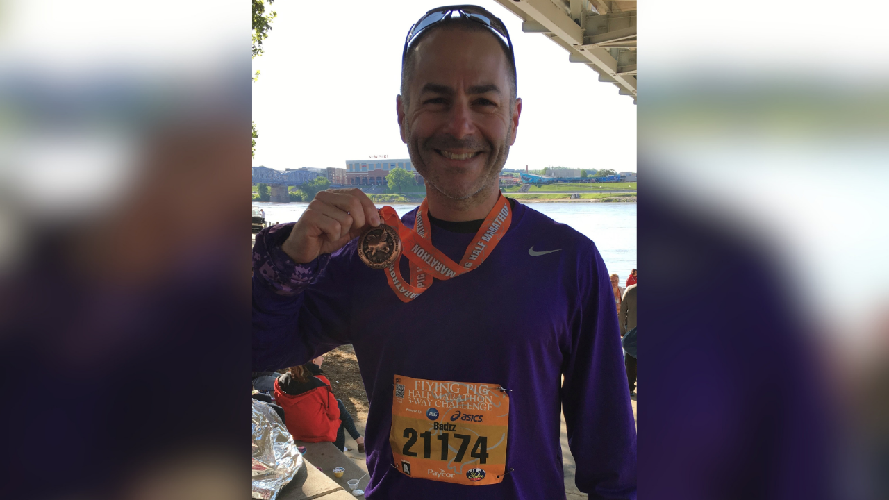 Scott Badzik smiles with his medal after a Flying Pig Marathon