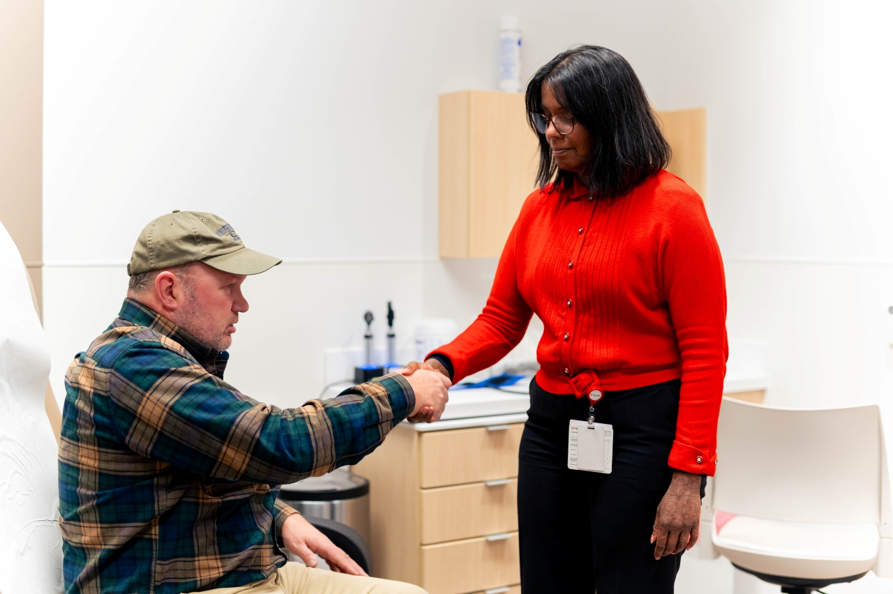 A medical provider shakes the hand of a patient in a medical setting. 