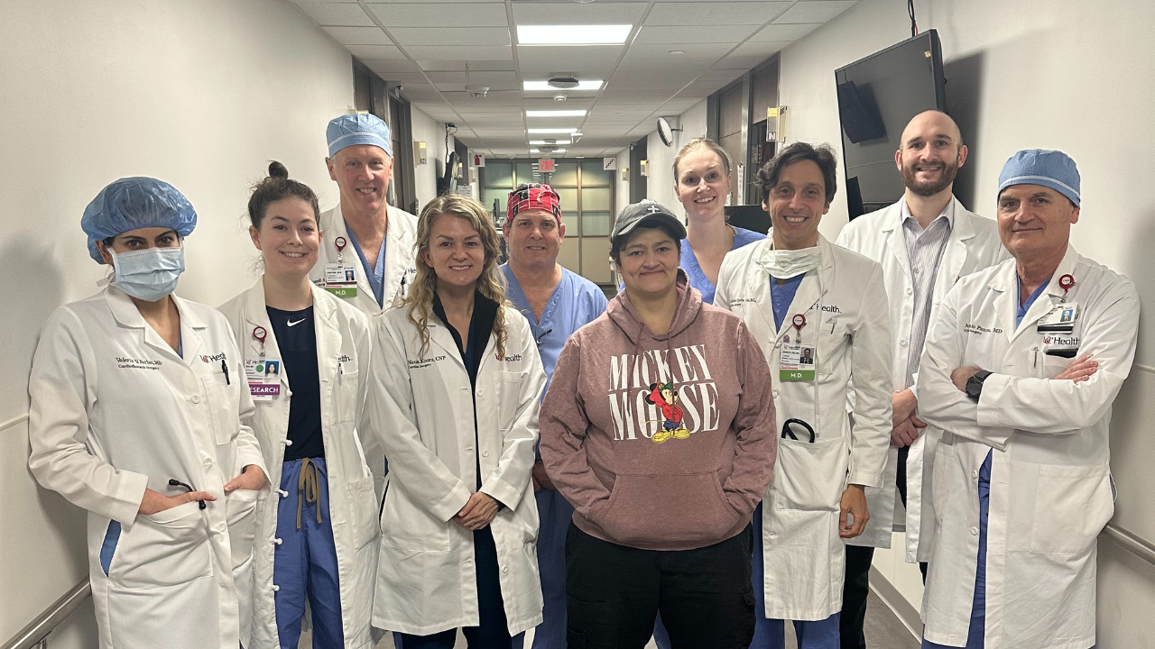 The UC Health cardiac surgery team and patient smile for a group photo