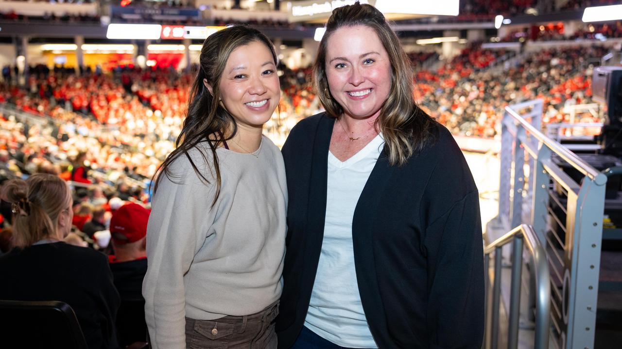 Jenny Hammond and Dr. Tang smile together at a UC Bearcats Men's Basketball game