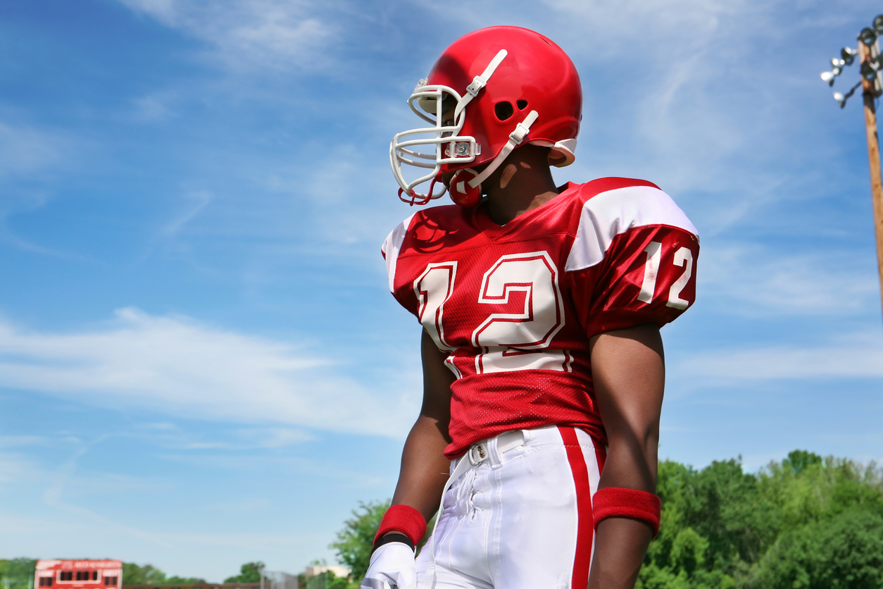 Football player wearing a red uniform and football protective equipment