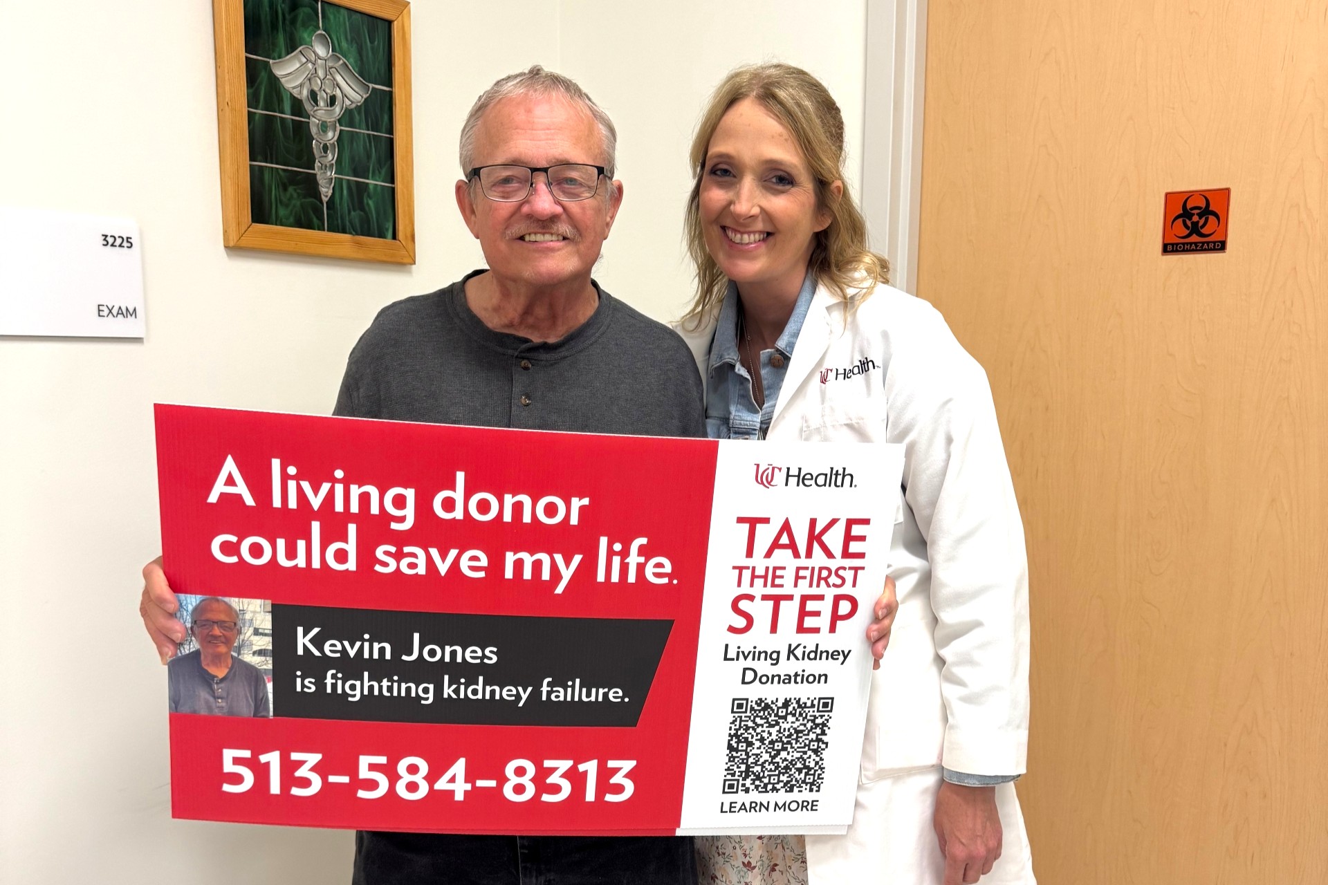 Patient holding a living donor sign stands next to physician in a medical environment.