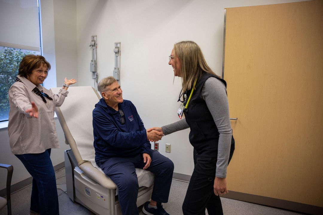 Bob and Diane shake hands with Brandy Klugg at UC Health